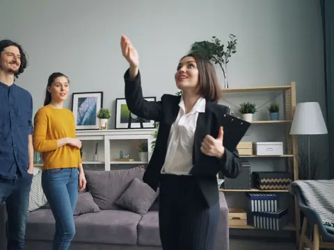 An agent showing a living room to two visitors