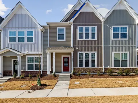 A row of new townhomes in grey and blue siding with front steps