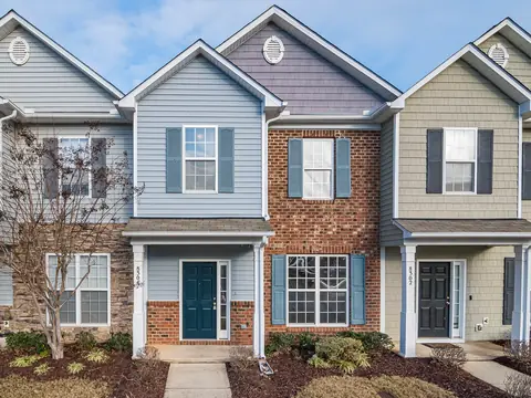A row of townhomes with brick and colored siding and blue shutters